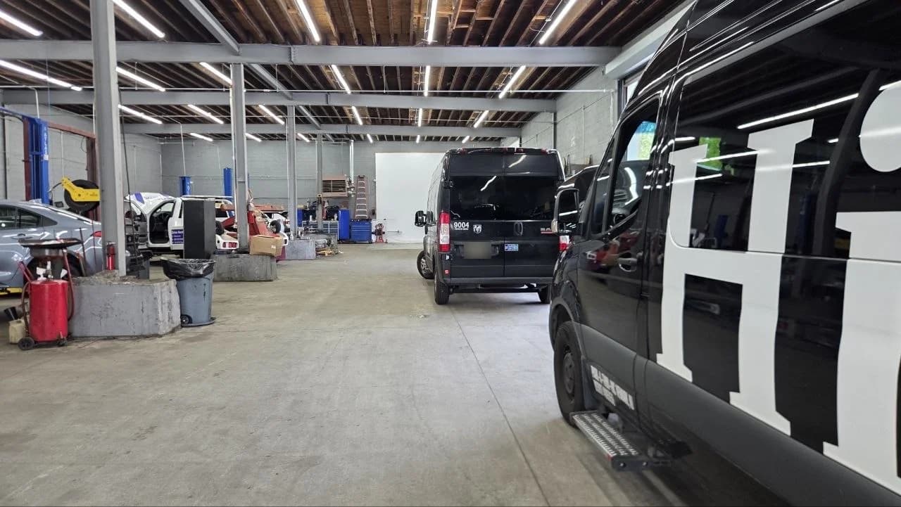 Wide view into the Newark workshop with shuttle vans and repair bays